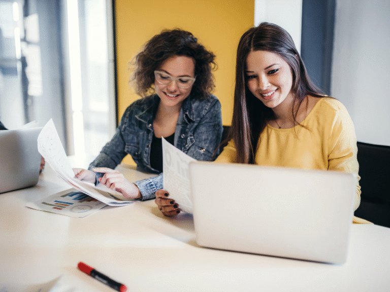 Two Gen Z women reviewing budget plans and building emergency funds