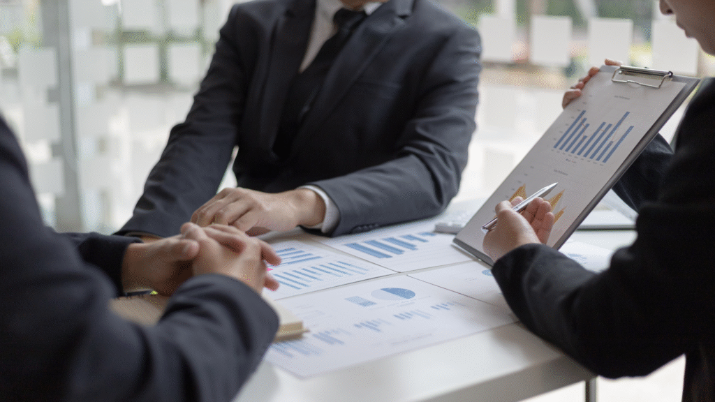 Financial advisors discussing investment performance and growth charts in a business meeting.