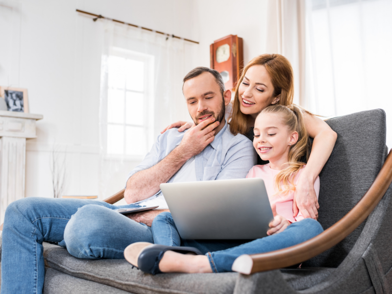 Parents with a young child using a laptop to plan long-term retirement and family finances