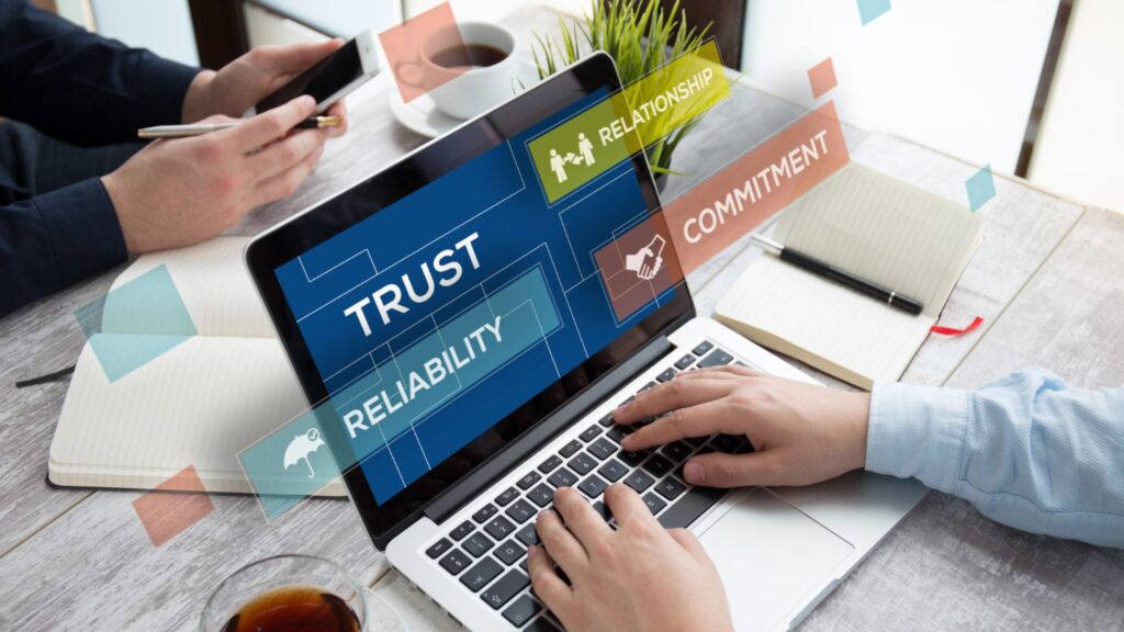 Work with trusted advisors illustration showing business professionals using a laptop with trust, reliability, and commitment displayed on screen